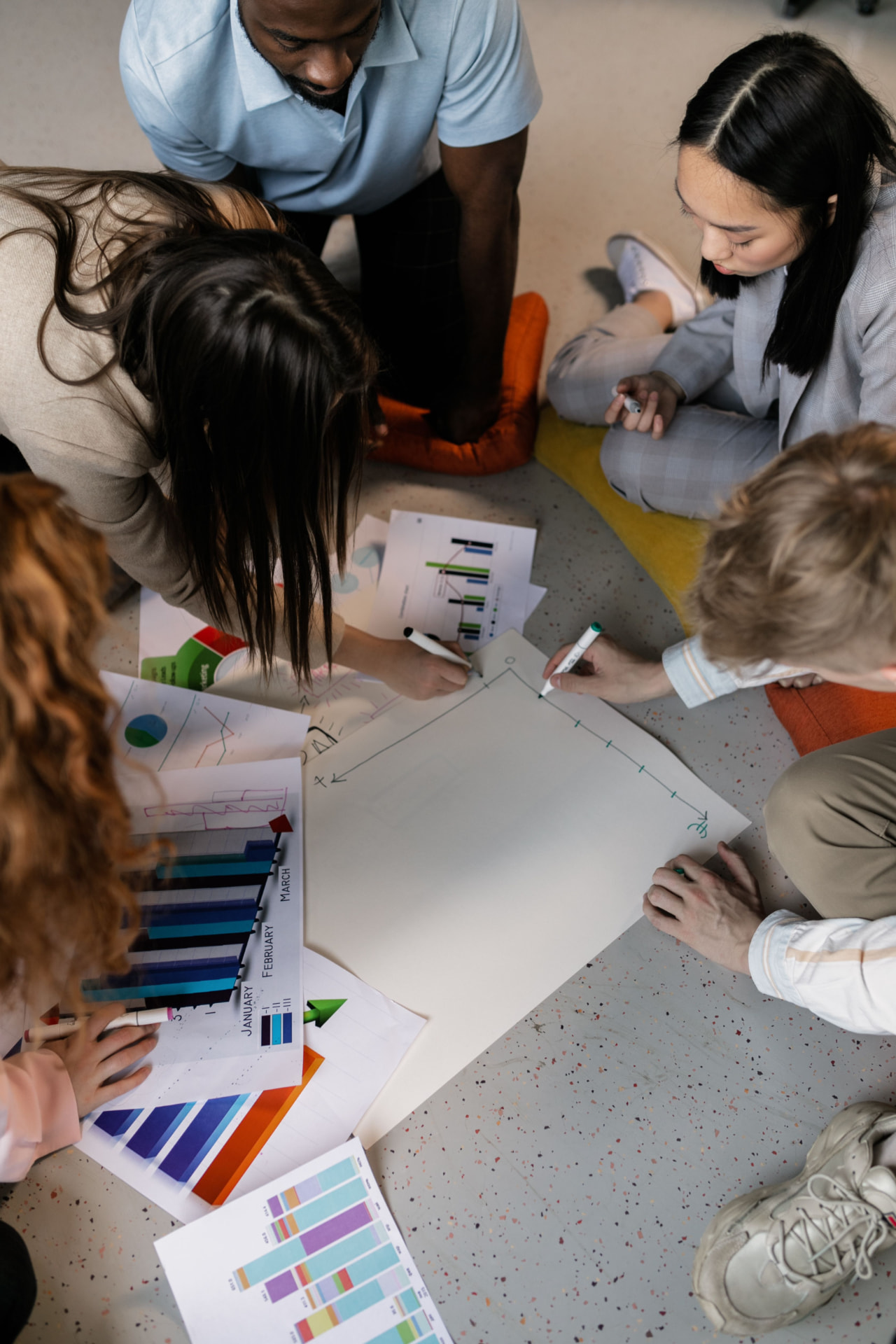 Equipe multidisciplinar organizando gráficos e planos de atendimento em trabalho colaborativo.