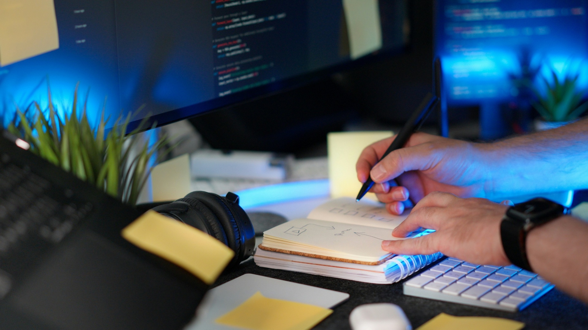 Planejamento técnico de projeto de TI em bancada com monitores e caderno de anotações — Vale IT Solutions.