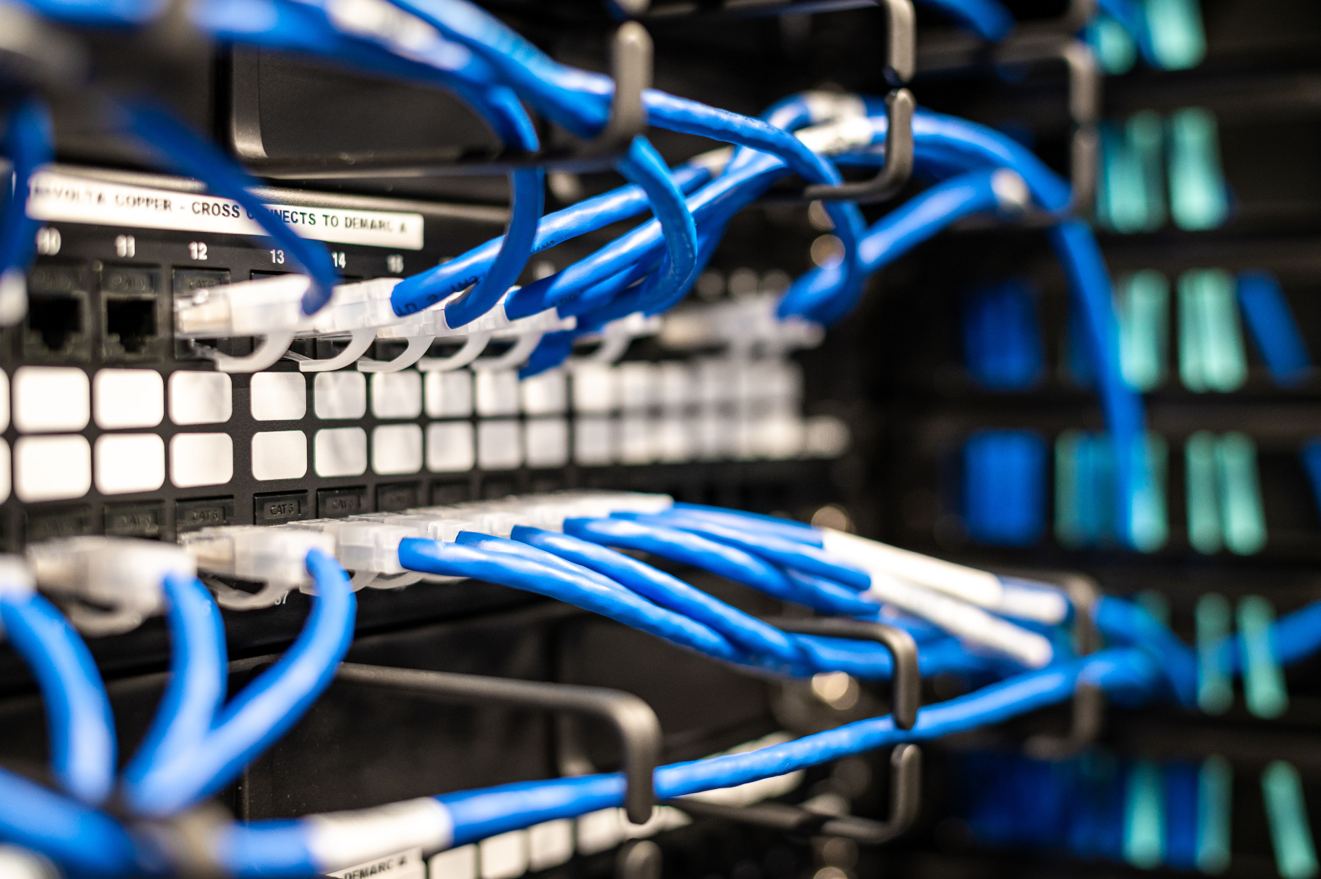 Cabeamento estruturado azul em rack de rede durante levantamento técnico Vale IT Solutions.